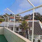 Área de cobertura protegida com rede de proteção para gatos e estrutura em alumínio no bairro Roçado em São José Santa Catarina.